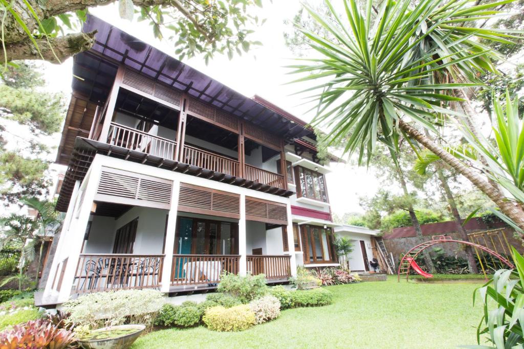 a house with a balcony and a yard at Rumah Pelita near Lembang FREE WIFI - Villa Lantera in Bandung