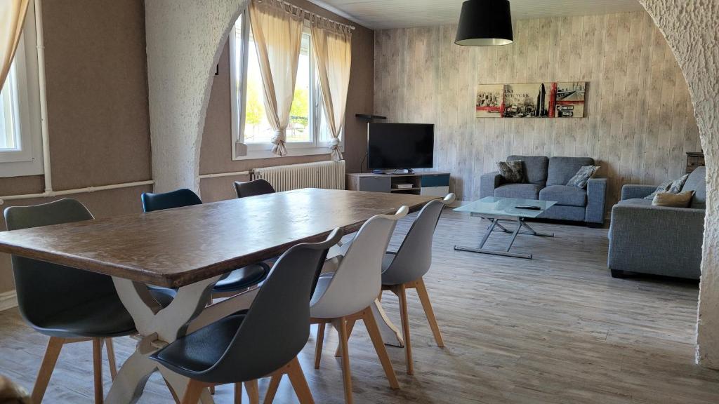 una sala de estar con una gran mesa de madera y sillas en Maison familiale à Haybes, en Haybes