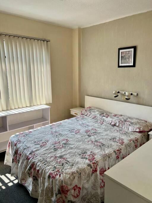 1 dormitorio con 1 cama con colcha de flores en Departamento ejecutivo céntrico, bien comunicado, en Ciudad de México