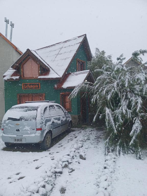 un coche aparcado frente a una casa cubierta de nieve en La Protegida en El Chaltén