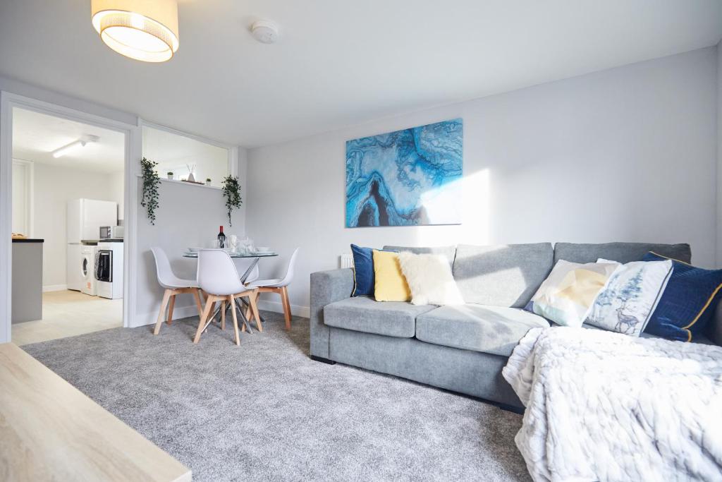 ein Wohnzimmer mit einem Sofa und einem Tisch in der Unterkunft homely - Great Yarmouth Beach Apartments in Great Yarmouth