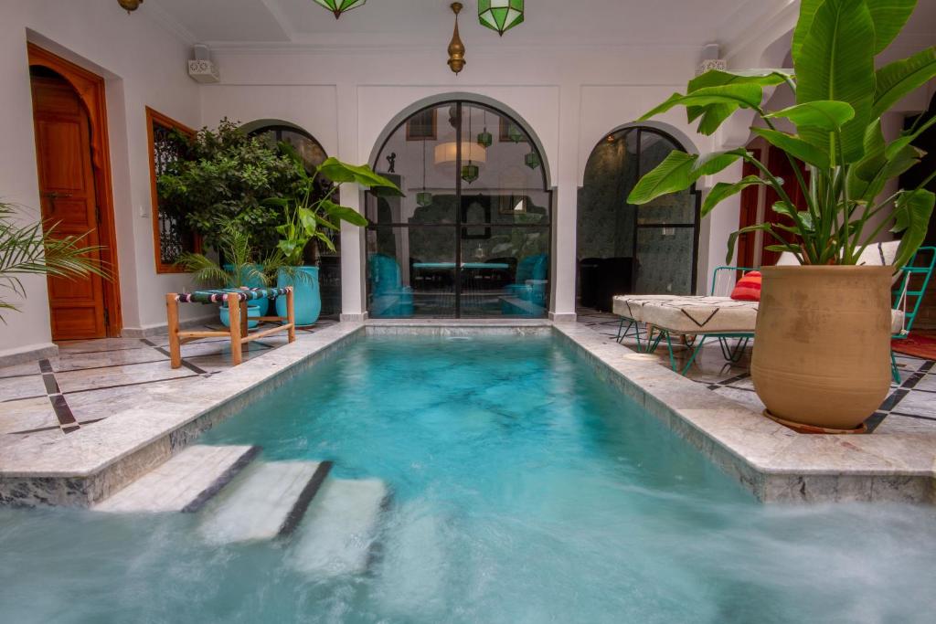 - une piscine d'eau bleue dans une maison dans l'établissement Riad SofYan & Spa, à Marrakech