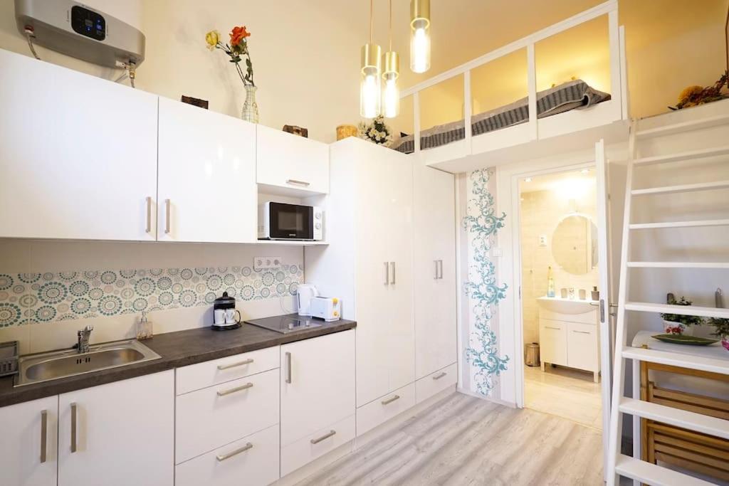 a kitchen with white cabinets and a sink at R69 Apartment in Budapest
