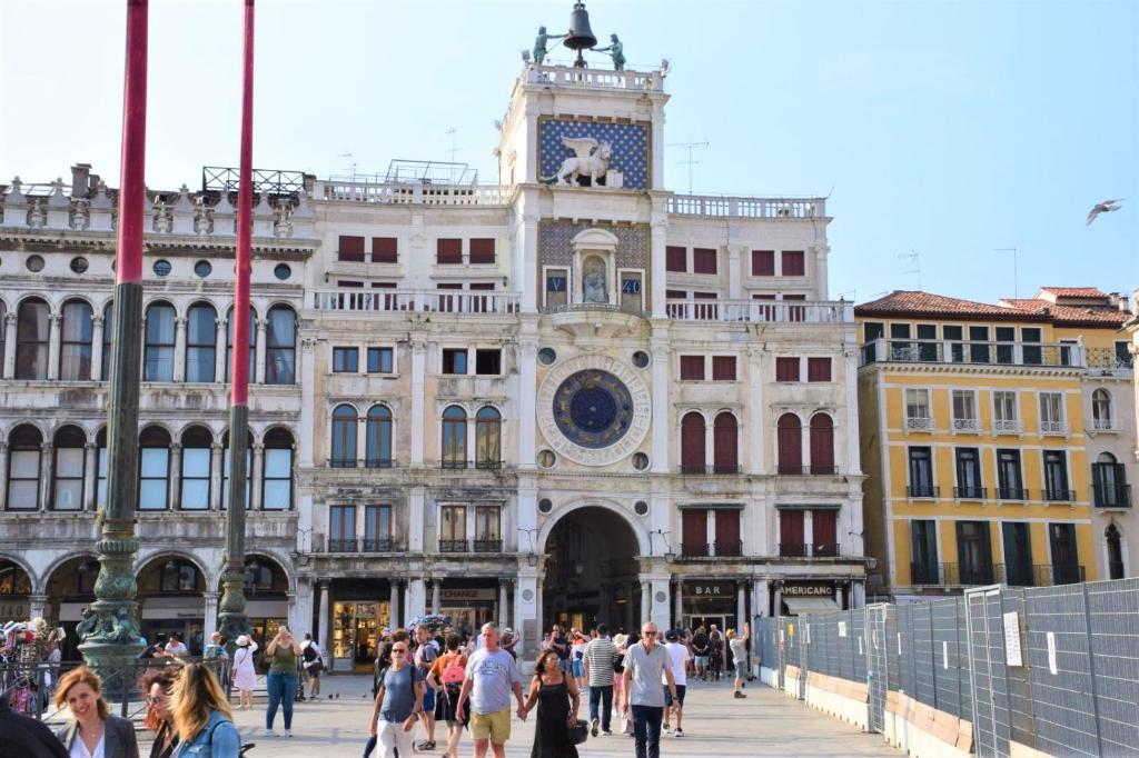 a group of people walking in front of a building with a clock tower at Le Pizzocchere in Venice