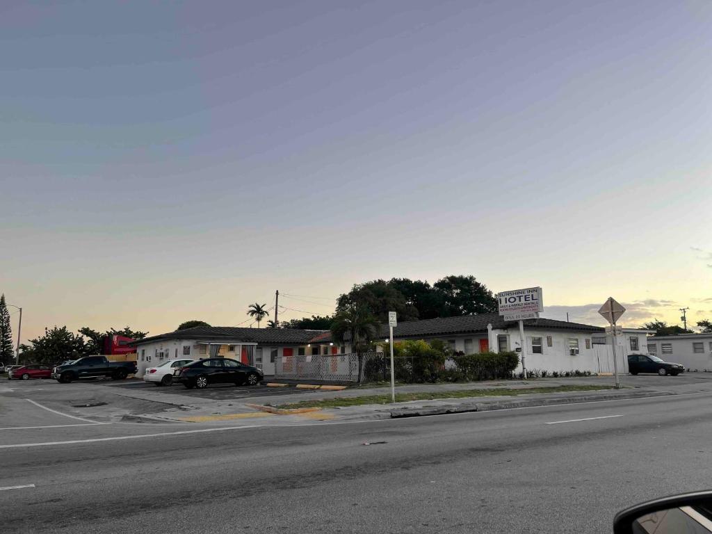 una calle vacía con coches aparcados frente a un motel en Sunshine Inn of Miami, en Miami