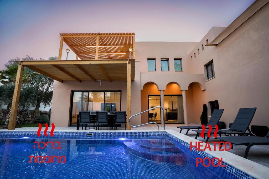 a swimming pool in front of a house at וילה רוני בריכה מחוממת Villa Roni Heated pool in Eilat