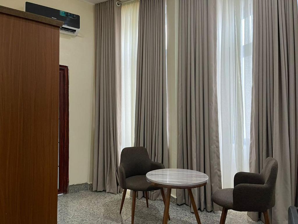 a room with two chairs and a table and a window at De Silver Green Luxury Hotel in Abuja