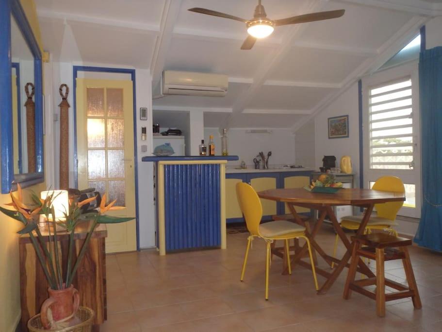 a kitchen and dining room with a table and chairs at Charmant et spacieux studio à 50m de la plage in Le Diamant