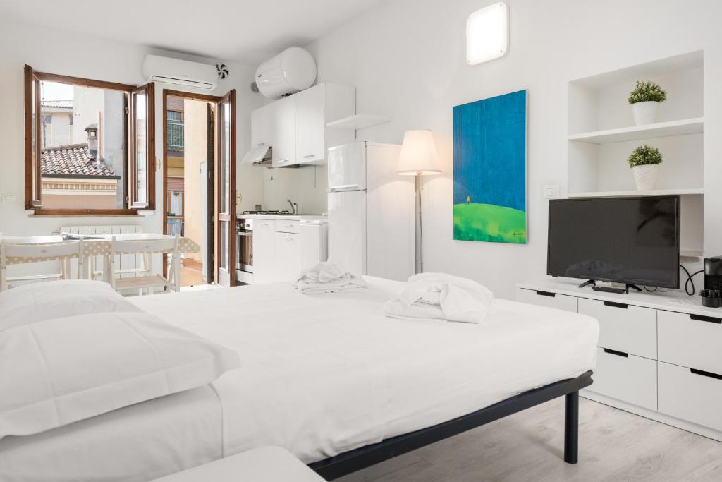 ヴェローナにあるPISANO12の白いベッドルーム(大型ベッド1台、テレビ付)