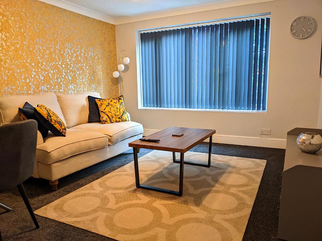 a living room with a couch and a table at Racecourse Apartment in Doncaster