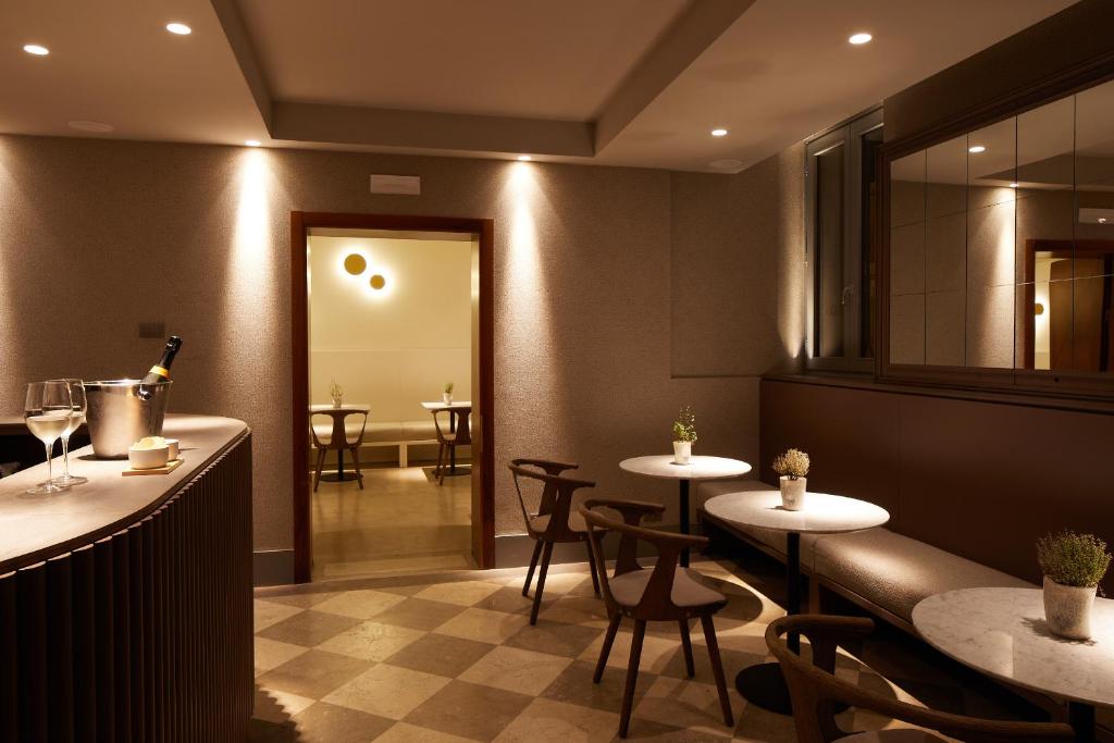 a restaurant with two tables and chairs and a mirror at Hotel Dei Dragomanni in Venice