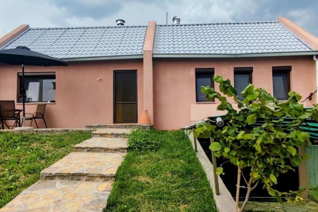 a pink house with a pathway leading to it at Evaggelia's Apartments 4 Σπίτι στο λιβάδι 