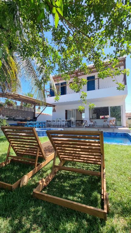 a couple of benches in front of a house at Vila Leão do Norte in Japaratinga