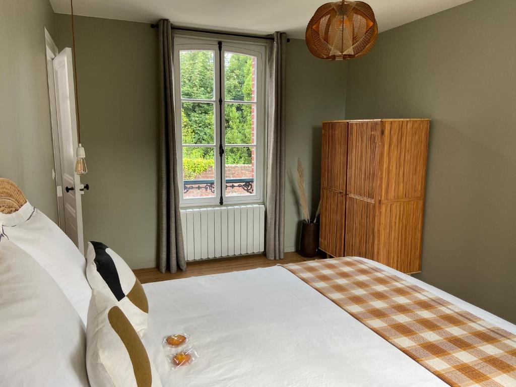Schlafzimmer mit einem Bett und einem Fenster in der Unterkunft GÎTE DE LA MUSARDE in Villers-sur-Mer