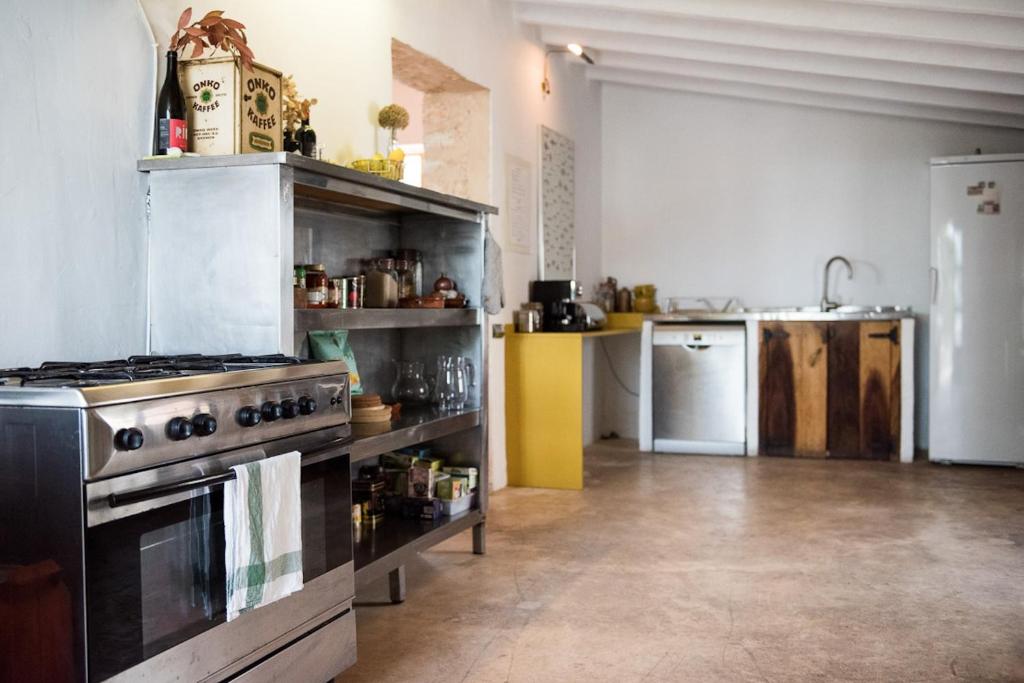 a large kitchen with a stove and a sink at Elegant Restored Luxury 600 Year Old Farmhouse I Las Chumberas I 6 Bedrooms I Stunning Views I Santa Gertrudis in Santa Gertrudis de Fruitera