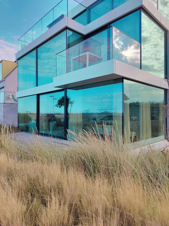 a glass building with a tree in front of it at La Naturale Garden zeezicht in Zeebrugge
