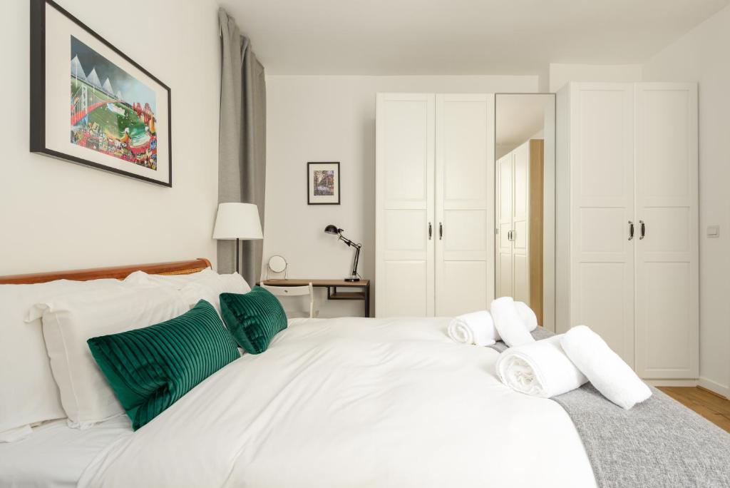 a bedroom with a white bed with green accents at The Grassmarket Apartment in Edinburgh