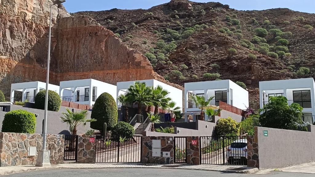 une rangée de maisons blanches devant une montagne dans l'établissement Casas de Tauro, à La Playa de Tauro