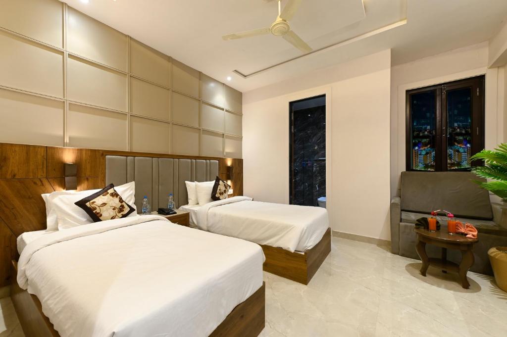 a hotel room with two beds and a window at Hotel Avalon Palms Agra in Agra