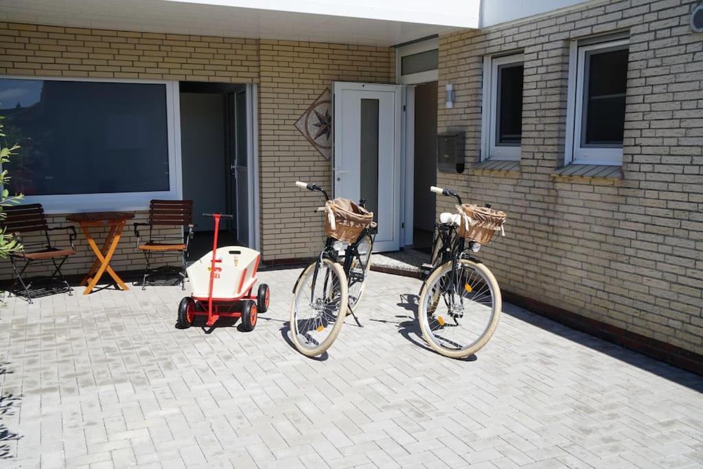 duas bicicletas estacionadas ao lado de uma casa com um carrinho de bebé em Küsters Ferienhaus Tinchen em Norden