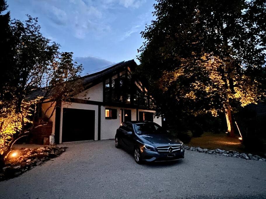a black car parked in front of a garage at Unique Sustainabel Lodge in the Swiss Jura Mountains in Neuchâtel