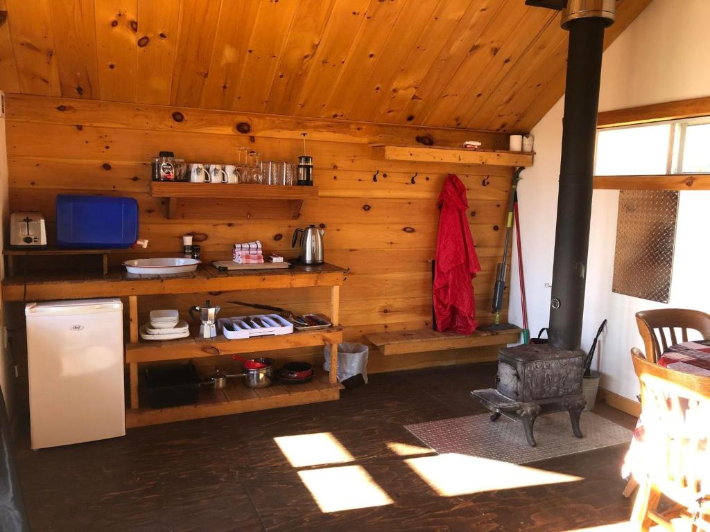 a kitchen with wooden walls and a refrigerator in a room at Les Cabines Nordik 2.0 in Shawinigan