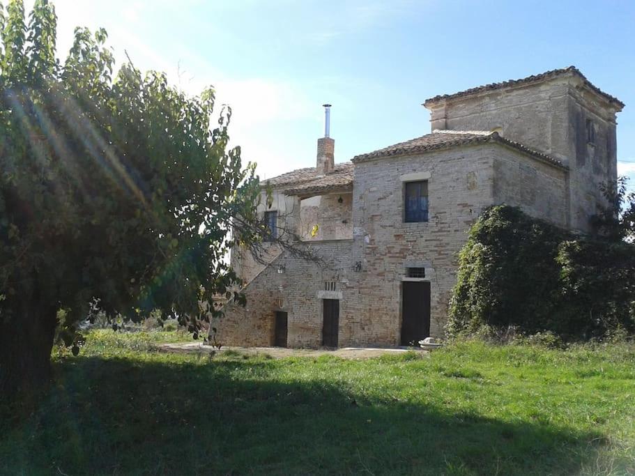 stary kamienny dom siedzący na trawniku w obiekcie Country House La Torretta di Gaglierano w mieście Citta' Sant'Angelo
