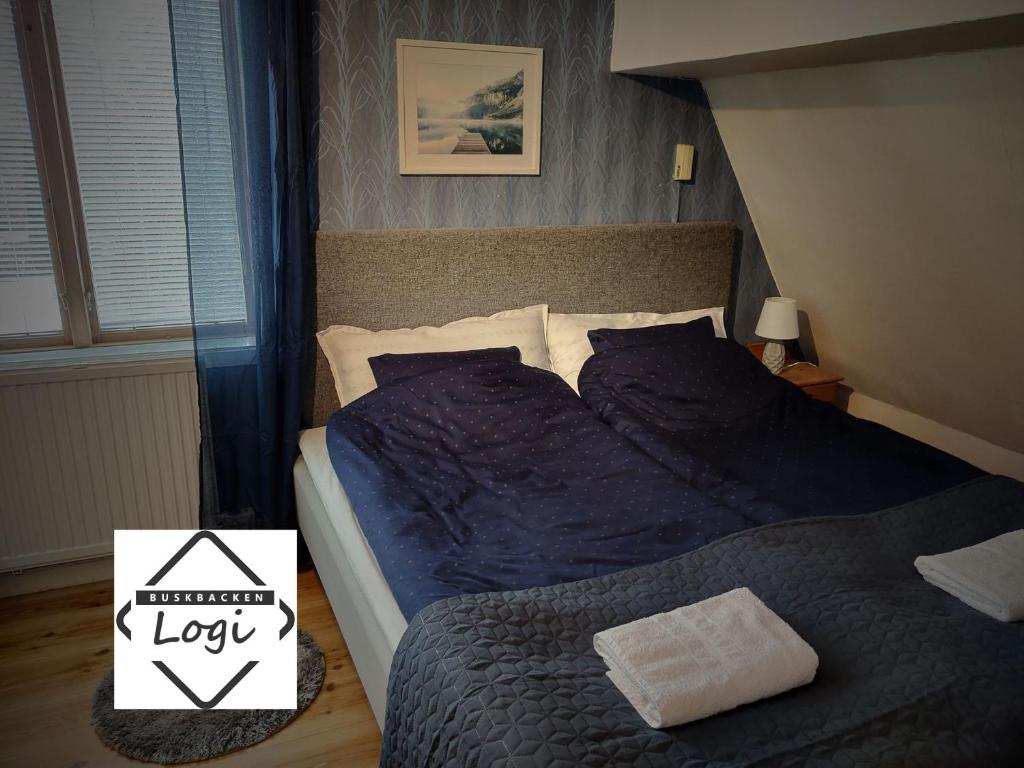 Buskbacken Logi في بولناس: غرفة نوم مع سرير مع لحاف أزرق