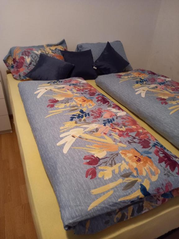 two beds with colorful comforters on them at Apartman Duman in Livno