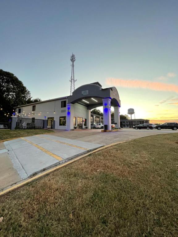 una gasolinera con luces azules en un aparcamiento en Garden Inn & Suites, en Hogansville