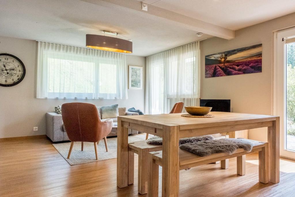Apartment Mühlegaden - GRIWA RENT AG في جريندلفالد: غرفة طعام مع طاولة وكراسي