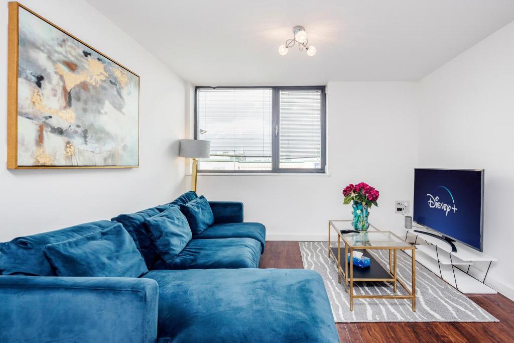 a living room with blue couches and a tv at 2-Bed Apartment Near Basildon Train Station in Basildon