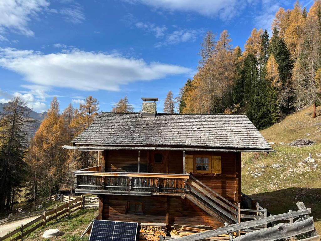 a log house with a solar panel in front of it at Kilge Alm in Großkirchheim