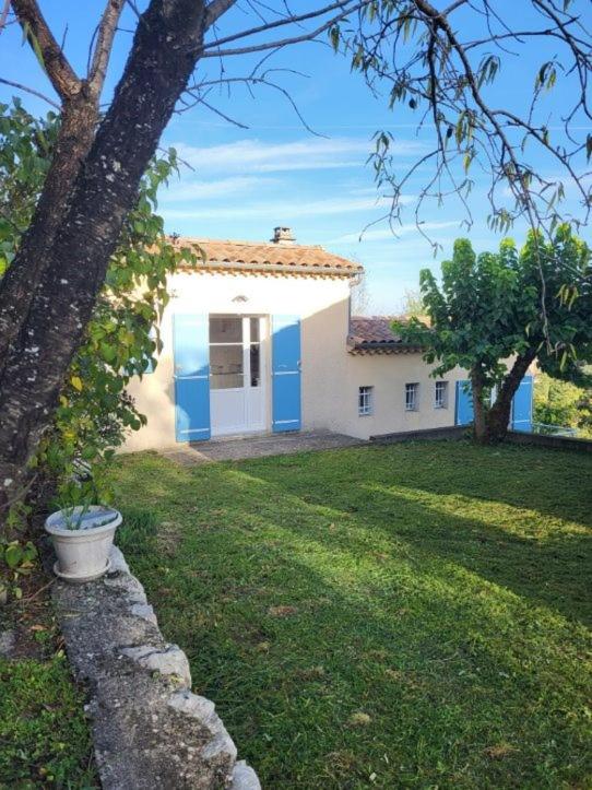 Biały dom z niebieskimi drzwiami i ogródkiem w obiekcie Nid douillet - LES FARGETTES - superbe vue - charmante petite maison avec jardin - 2 pièces à Privas w mieście Privas