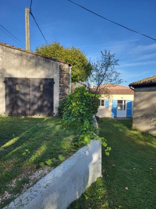 podwórko z budynkiem z bramą i trawnikiem w obiekcie Nid douillet - LES FARGETTES - superbe vue - charmante petite maison avec jardin - 2 pièces à Privas w mieście Privas