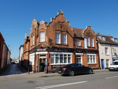 a black car parked in front of a brick building at Shakers Inn in Harwich