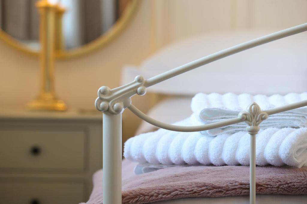 un letto con specchio e asciugamani. di Burgess Yard 2-bedroom cottage, Bath a Bath