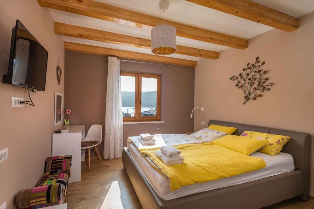 sypialnia z łóżkiem z żółtą pościelą i oknem w obiekcie Holiday home in Krnica - Istrien 38131 w mieście Krnica