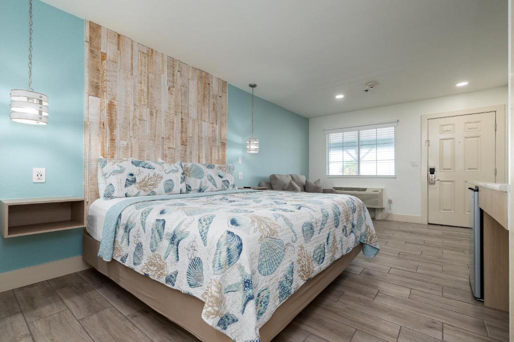 a bedroom with a bed with a blue wall at Bluff's Landing Marina & Lodge in Flour Bluff