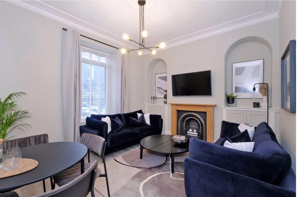 a living room with blue furniture and a fireplace at Granton Place in Aberdeen