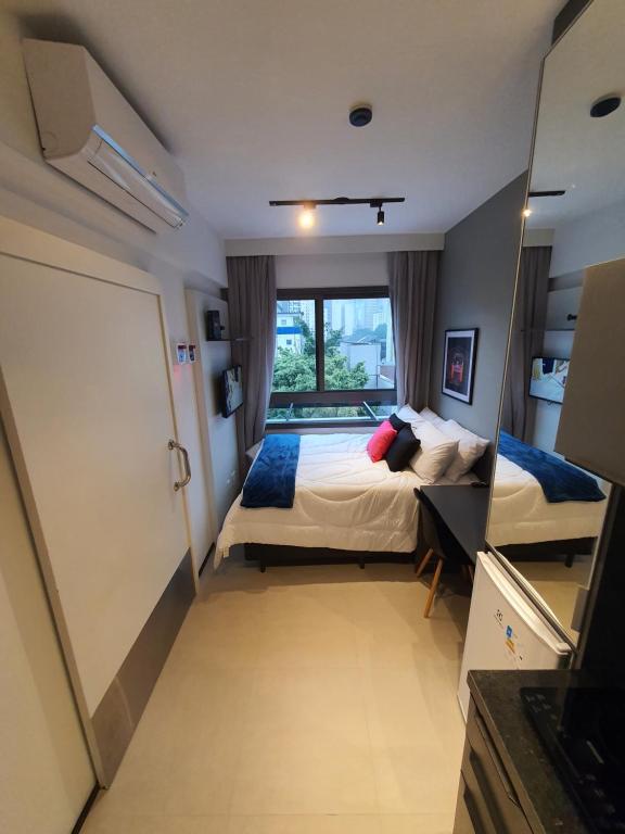 1 dormitorio con cama y ventana grande en Studio Allianz Perdizes en São Paulo