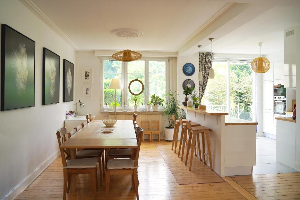 a kitchen and dining room with a wooden table and chairs at Superbe maison avec jardin magnifique! in Schiltigheim