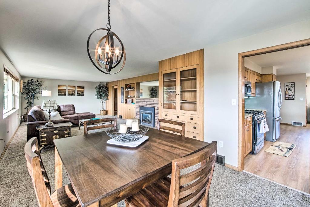 uma cozinha e sala de estar com uma mesa de madeira e cadeiras em Family-Friendly Yakima Escape with Yard and Pool! em Yakima