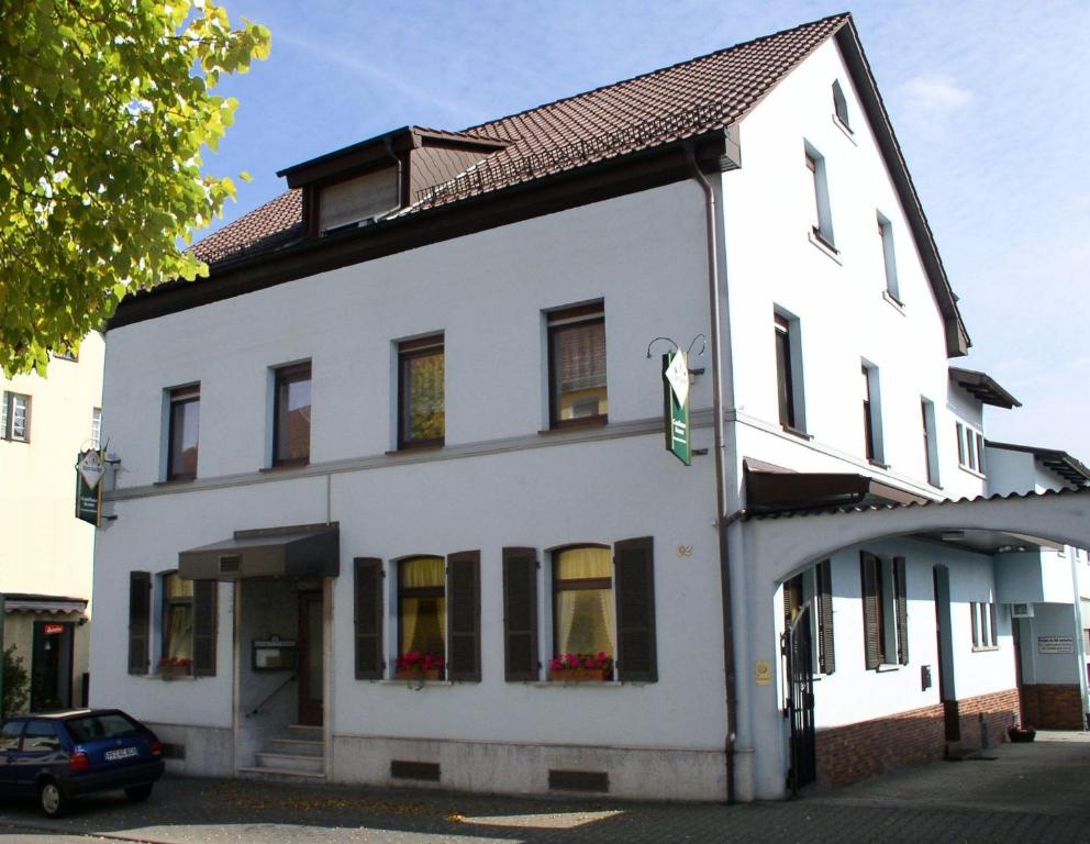 a white building with a green sign on it at Gasthaus Krone in Pforzheim