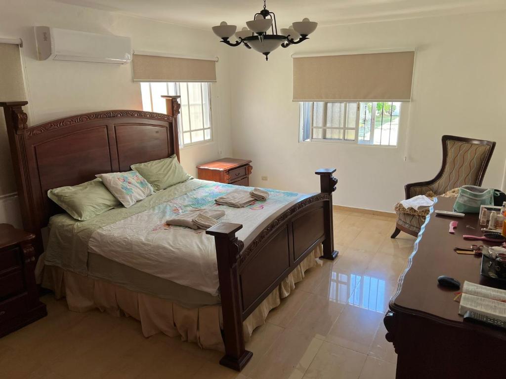 sypialnia z dużym łóżkiem i biurkiem w obiekcie Villa Caterina w mieście Dajabón