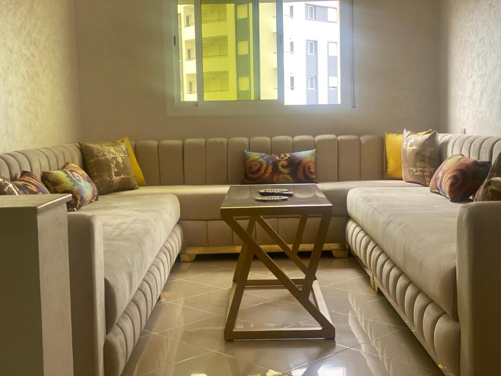 ein Wohnzimmer mit 2 Sofas und einem Tisch in der Unterkunft Jada Gzenaya in Tangier