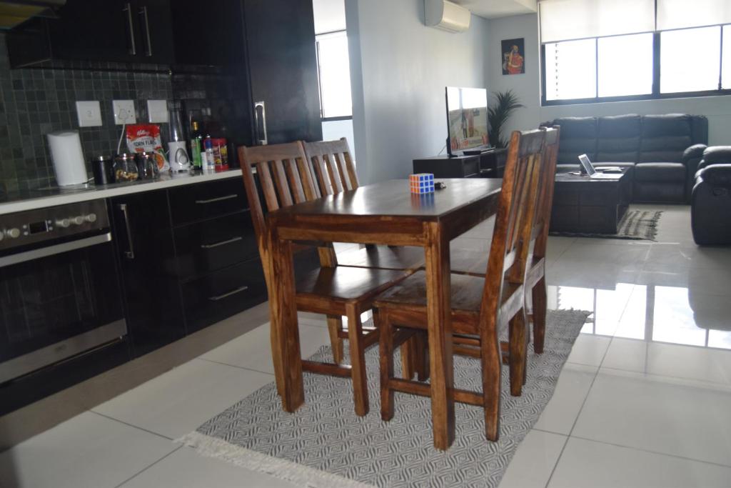 a kitchen with a wooden table and two chairs at Scenic Apartment in Windhoek City Centre in Windhoek