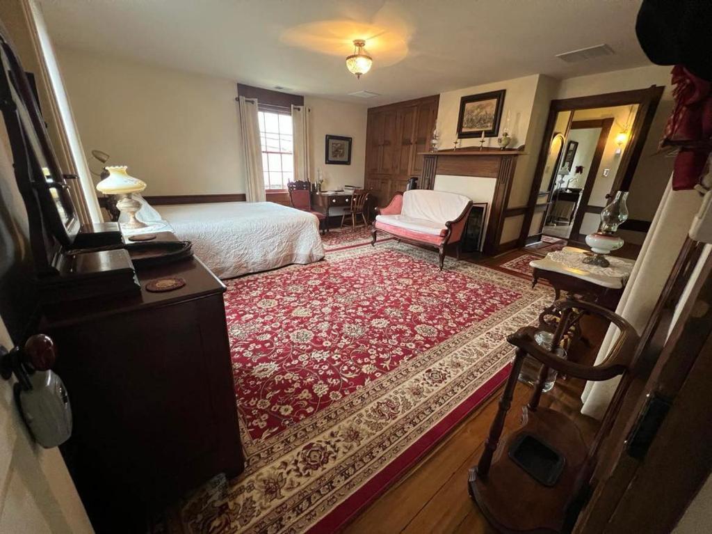 a bedroom with a bed and a living room at Upstairs Historic 1 Bedroom 1 Bath Suite with Mini-Kitchen, Porch & River Views in Elkins