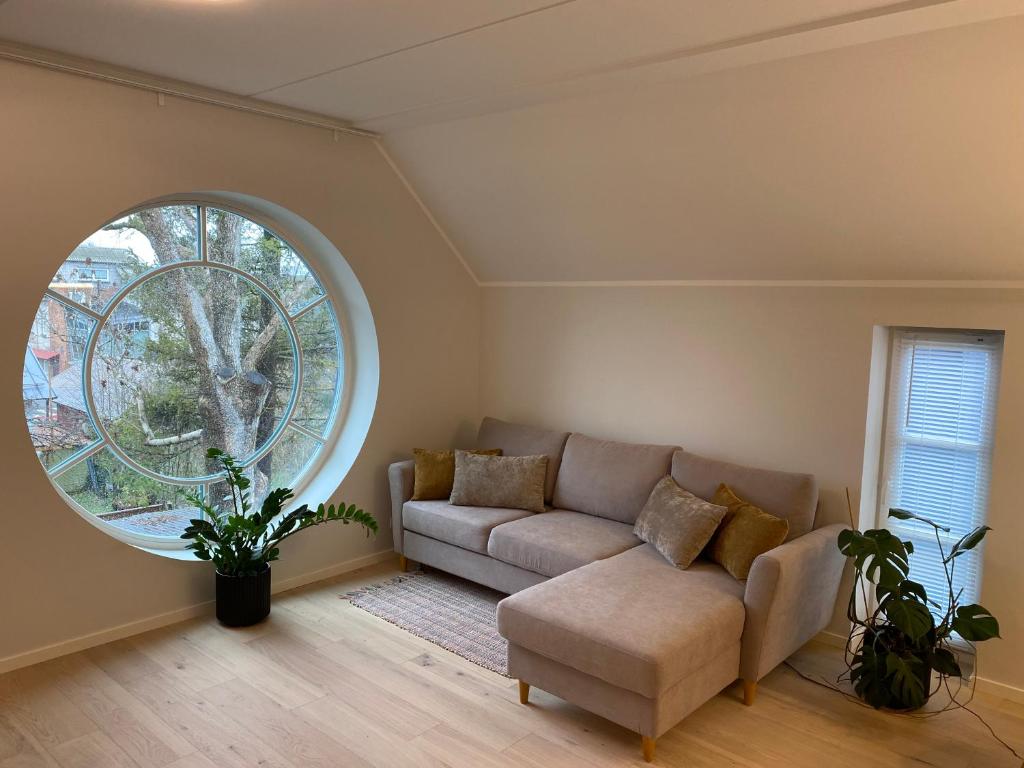 a living room with a couch and a large window at Modern Central Apartment HOTEL in Keila