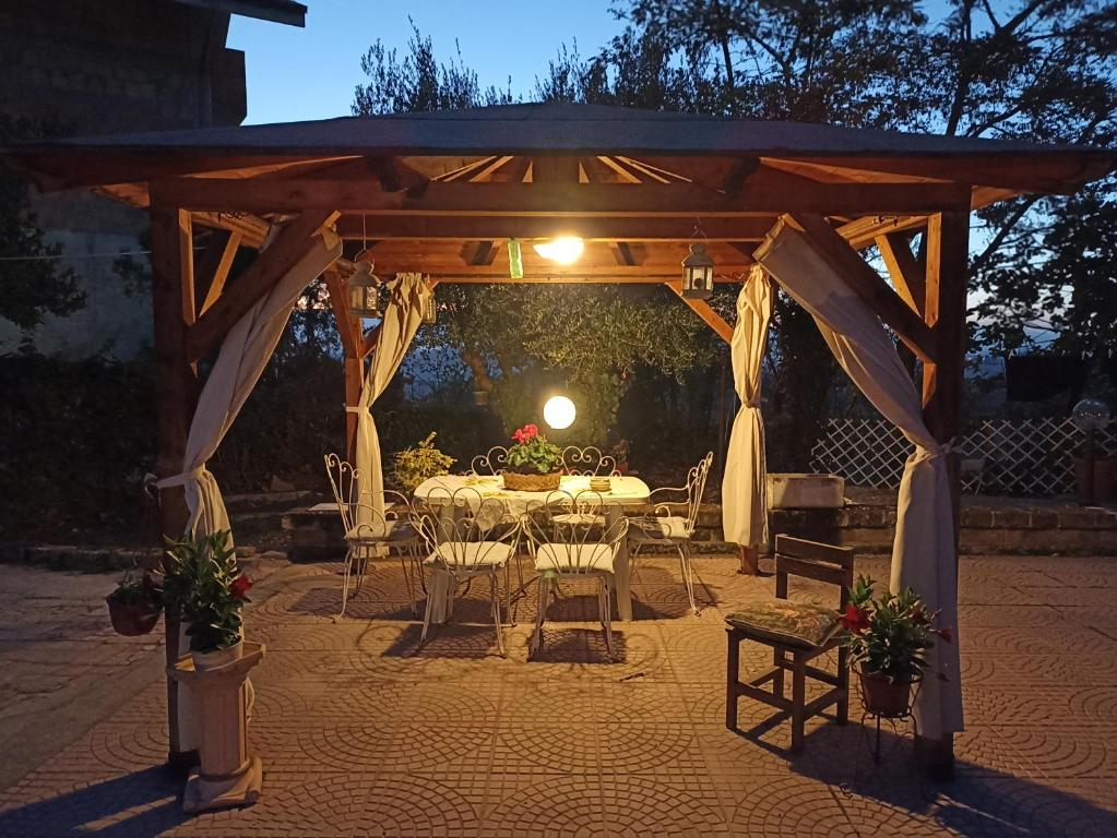 a wooden gazebo with a table and chairs at B&B LA BOUGANVILLE in Spoltore